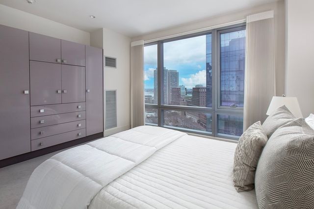 a bedroom with a large bed and a large window