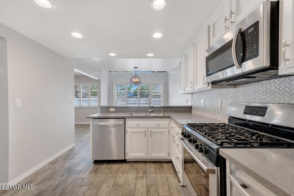 1980 Rory Lane, Unit 3 Simi Valley, CA 93063 - Photo 7 of 33 a kitchen with stainless steel appliances granite countertop a stove a sink and a microwave