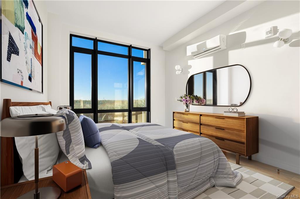 a bedroom with a bed and a large mirror next to a window