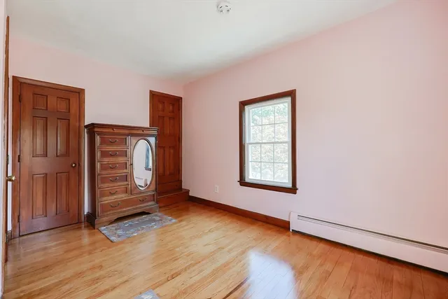 an empty room with wooden floor wooden cabinet and windows