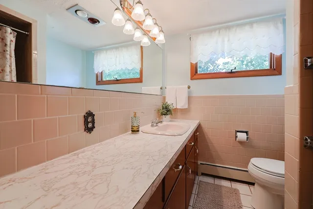 a bathroom with a granite countertop sink a large mirror and toilet