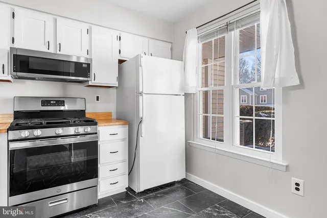 a kitchen with stainless steel appliances white cabinets and a stove a sink