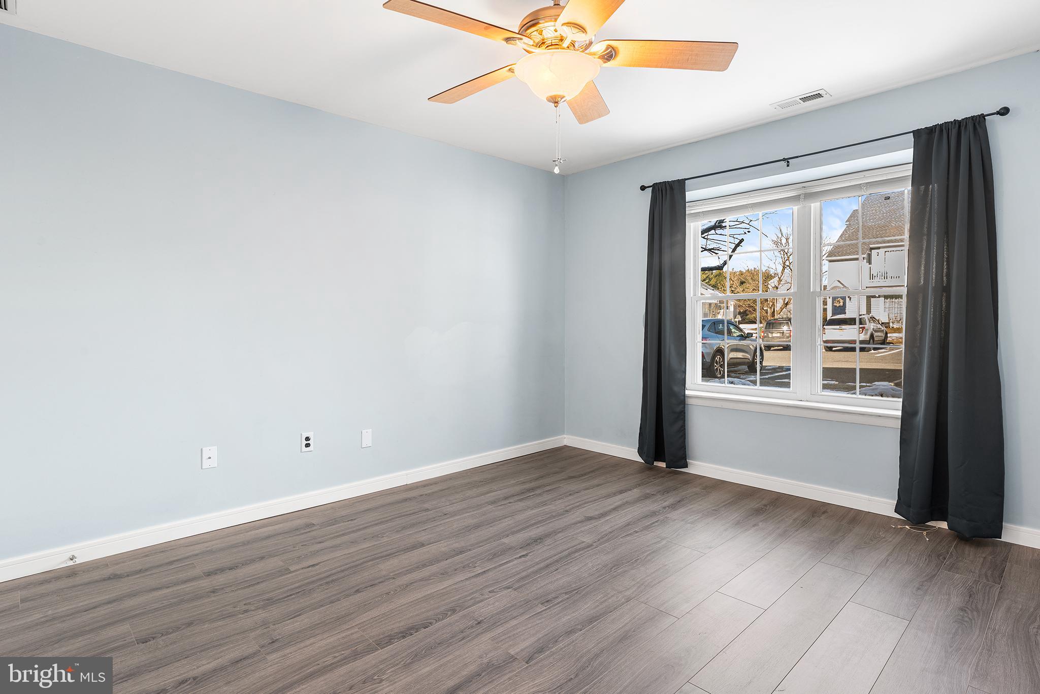 701 Sedgewick Court, Unit 701 Sewell, NJ 08080 - Photo 20 of 31 an empty room with wooden floor fan and windows