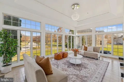 a living room with furniture and floor to ceiling windows