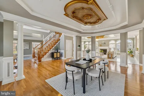 a dining room with furniture a chandelier and wooden floor