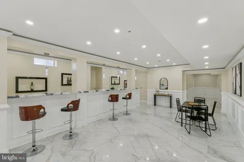 a kitchen with a sink and chairs