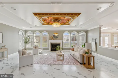 a living room with furniture a fireplace and a floor to ceiling window