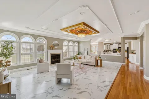 a living room with furniture large window and wooden floor