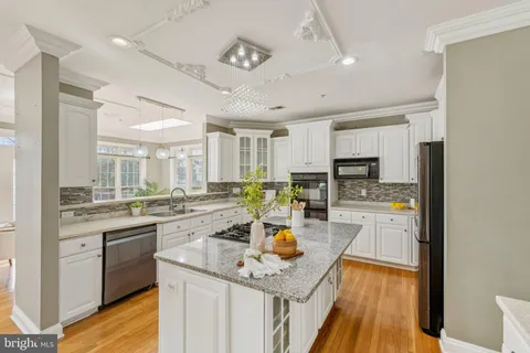 a view of a kitchen with kitchen island and stainless steel appliances