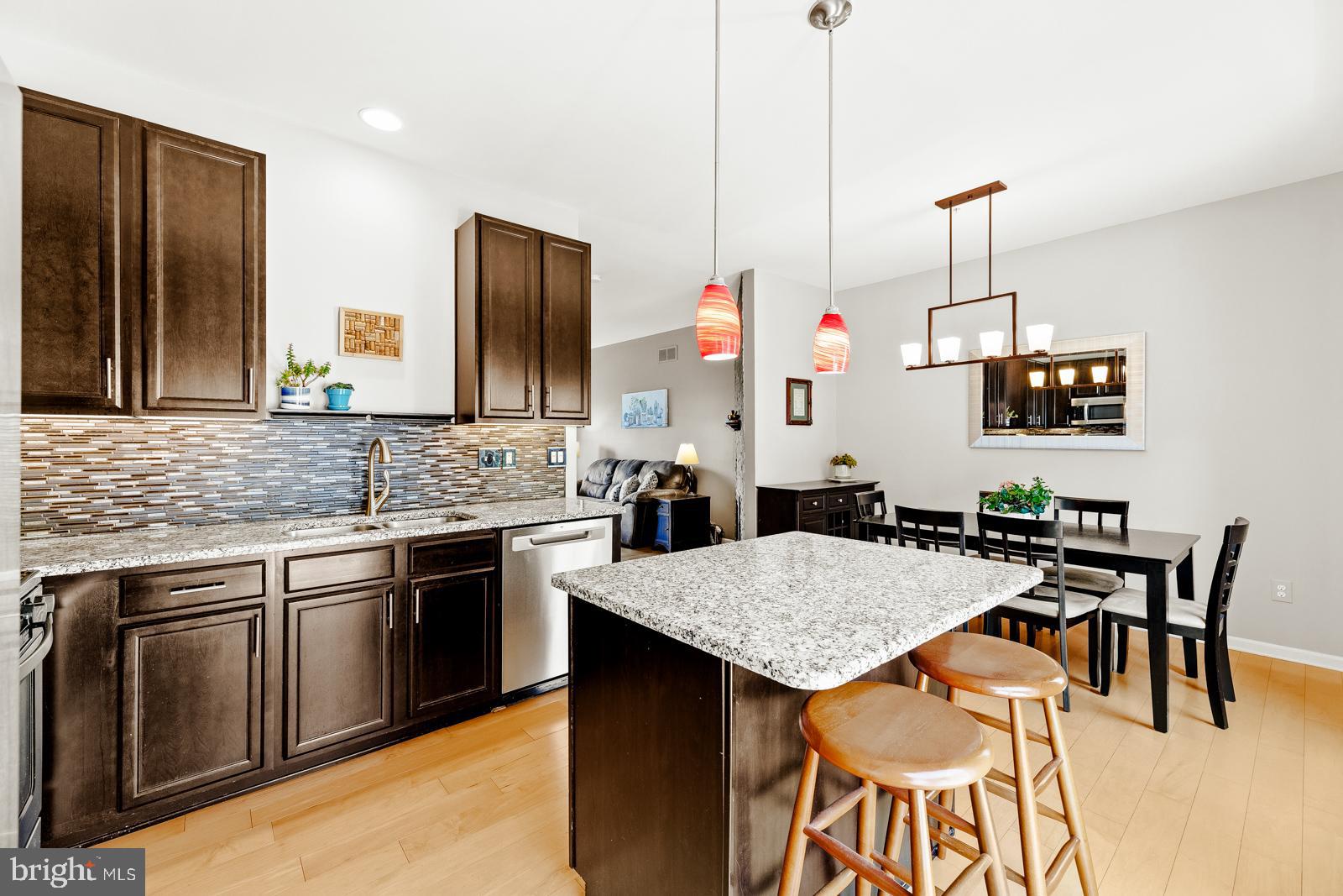 3669 Jacob Stout Road, Unit 8 Doylestown, PA 18902 - Photo 10 of 38 a kitchen with granite countertop kitchen island stainless steel appliances a stove top oven a sink a dining table and chairs