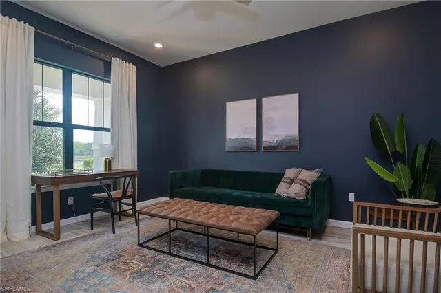 a living room with furniture a window and a potted plant
