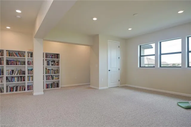 a view of an empty room with a window and cabinet