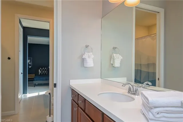 a en suite bathroom with a granite countertop sink and a mirror