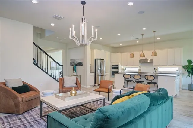 a living room with kitchen island furniture and a chandelier