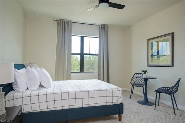 a bedroom with a bed a chair and a large window