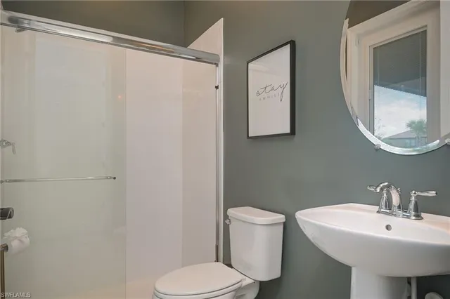 a white toilet sitting next to a bathroom sink