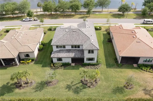 an aerial view of a house with swimming pool and a yard