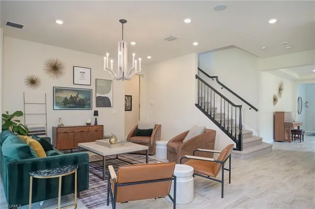 a living room with furniture and a chandelier