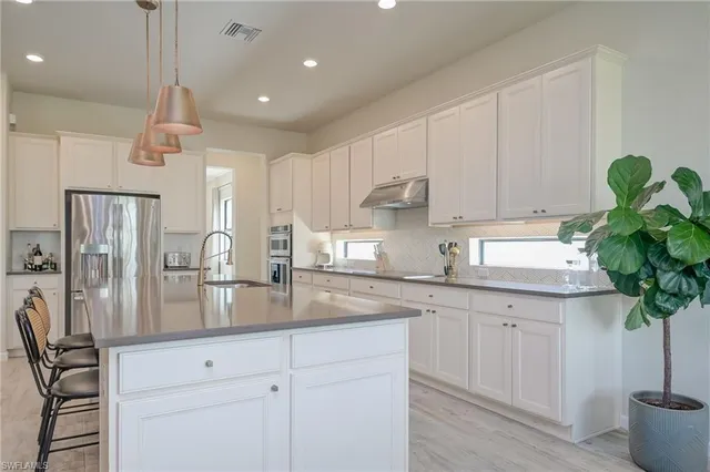 a kitchen with a white center island and cabinets