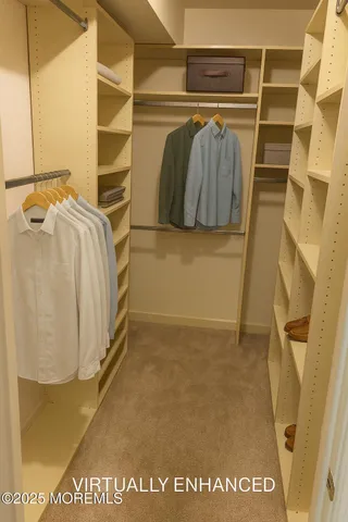 a view of walk in closet with clothes and shoes