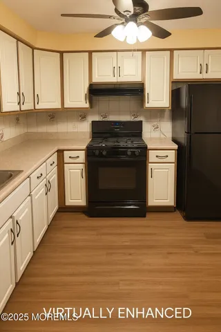 a kitchen with stainless steel appliances granite countertop a stove a sink and white cabinets