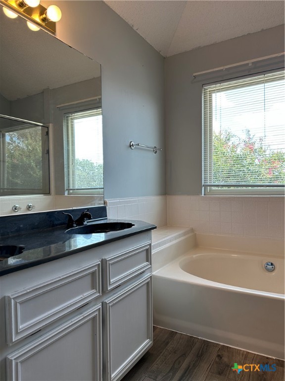 902 Tank Street Copperas Cove, TX 76522 - Photo 17 of 27 a bathroom with a granite countertop sink mirror bathtub and next to a window
