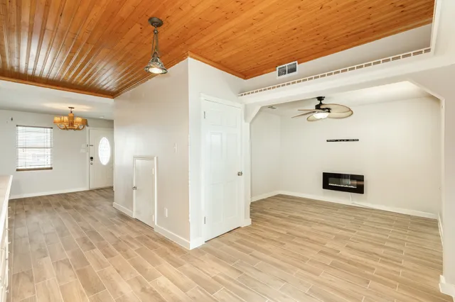 a view of a hallway with wooden floor and a cabinet