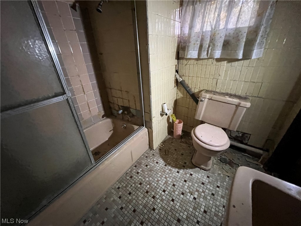 72553 Colerain Road Dillonvale, OH 43917 - Photo 26 of 31 Bathroom featuring combined bath / shower with glass door, toilet, tile walls, and tile flooring