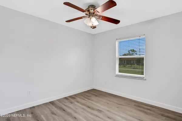 an empty room with a window and a ceiling fan
