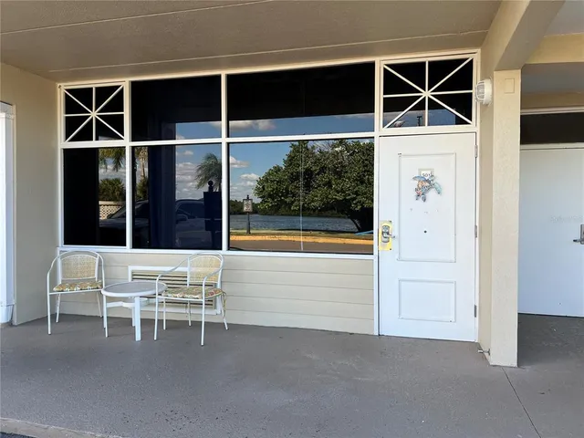 a view of an empty room with wooden floor and windows