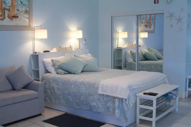 a bedroom with a bed a mirror and lamp