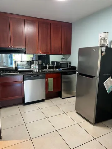 a kitchen with stainless steel appliances granite countertop a refrigerator sink and stove