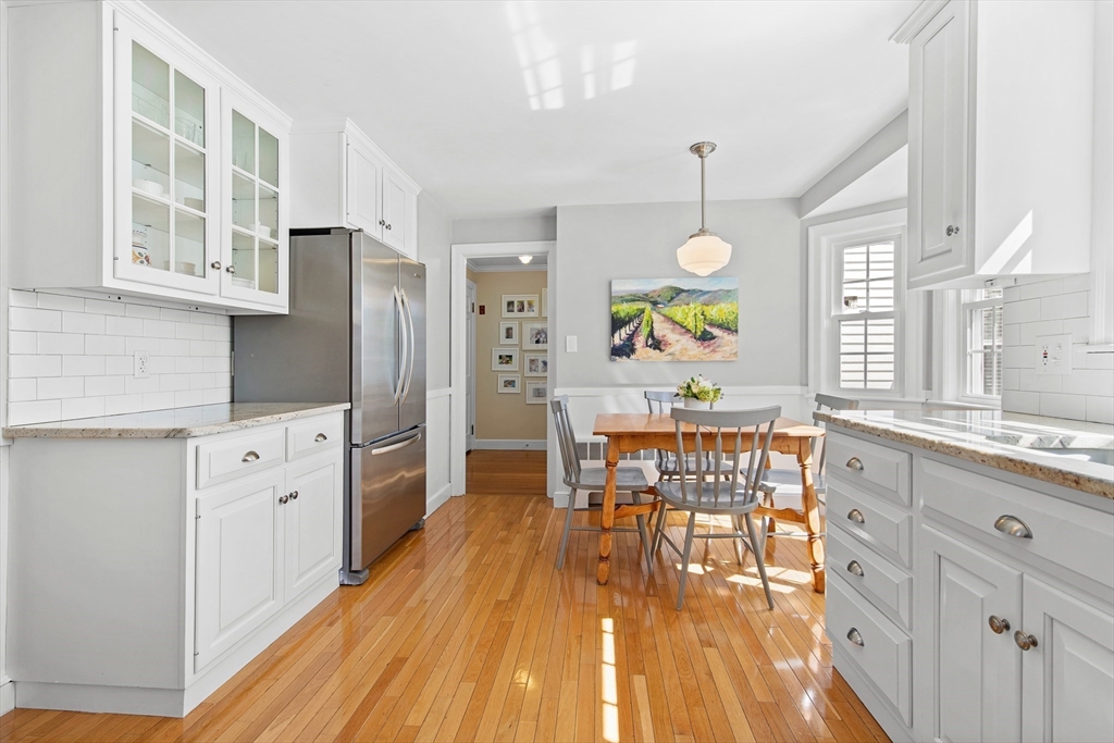 40 Eaton Road Needham, MA 02492 - Photo 13 of 27 a kitchen with stainless steel appliances granite countertop a stove a sink dishwasher a refrigerator dining table and chairs with wooden floor