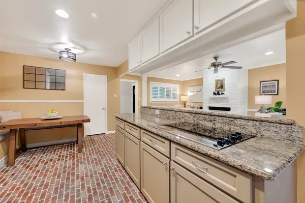 a living room with furniture a fireplace and a ceiling fan