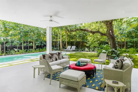 a view of a patio with couches chairs and a big yard