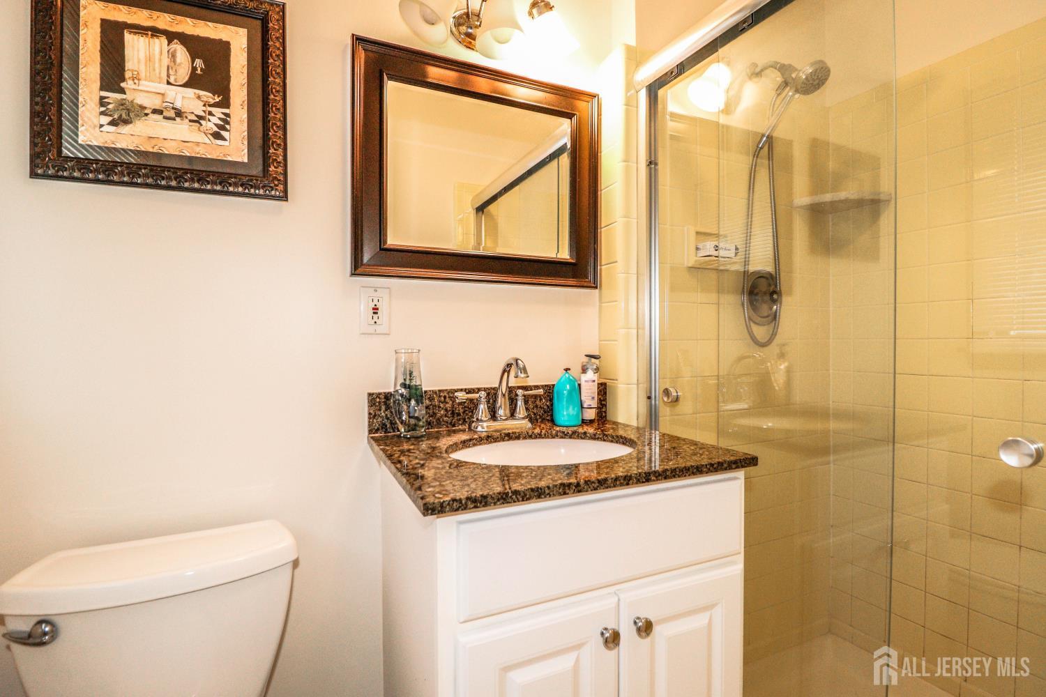 5 Timothy Court Edison, NJ 08837 - Photo 18 of 32 a bathroom with a granite countertop sink a toilet and a mirror