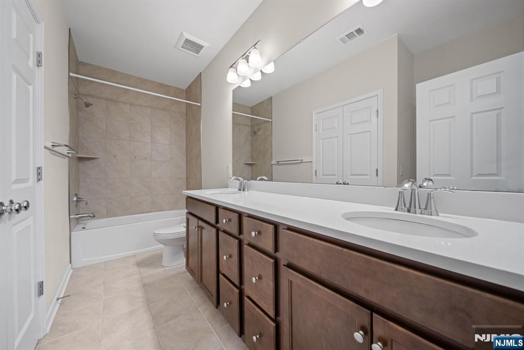 39 Arnold Drive Wood-Ridge, NJ 07075 - Photo 24 of 49 a bathroom with a granite countertop sink a mirror a bathtub and shower