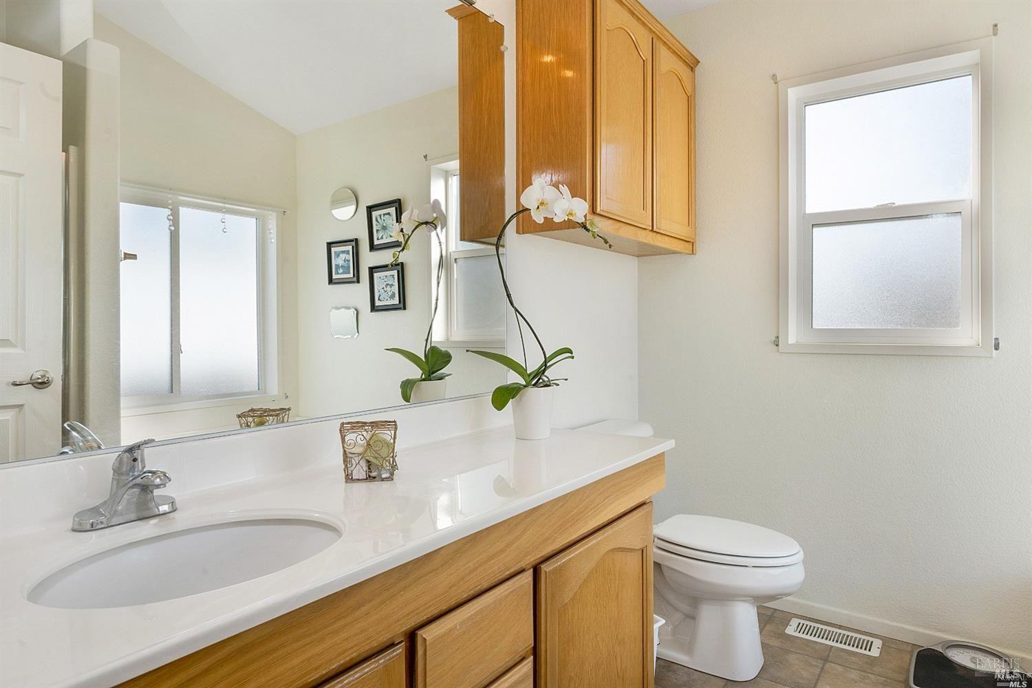 600 Colonial Park Drive Santa Rosa, CA 95403 - Photo 22 of 34 a bathroom with a granite countertop sink and a toilet