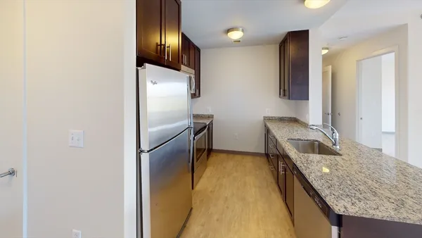 a kitchen with granite countertop cabinets and refrigerator