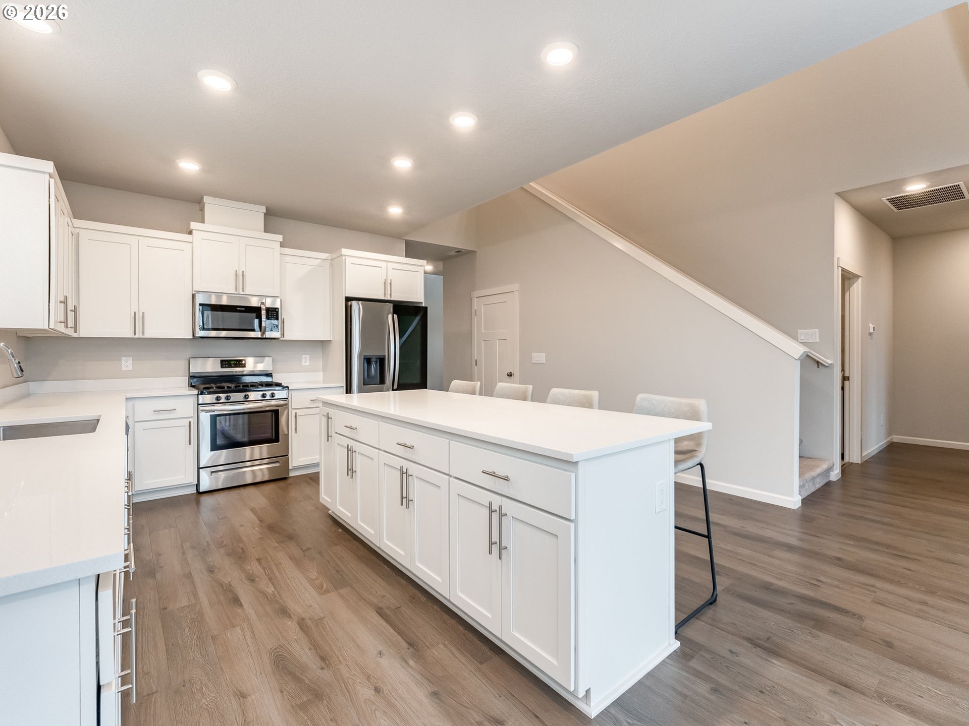 1663 Northwest Edgar Street McMinnville, OR 97128 - Photo 15 of 44 a kitchen with stainless steel appliances white cabinets a sink a stove a microwave and wooden floors