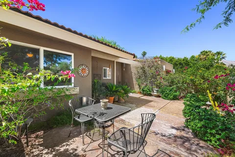 a view of a patio with table and chairs and potted plants