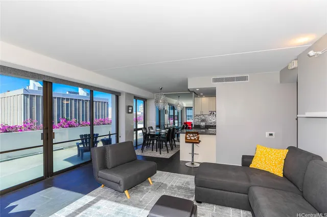 a living room with furniture and a view of kitchen