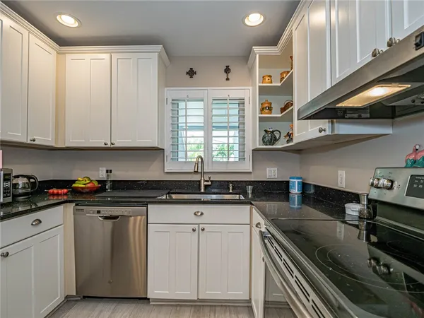 a kitchen with granite countertop a stove sink and cabinets