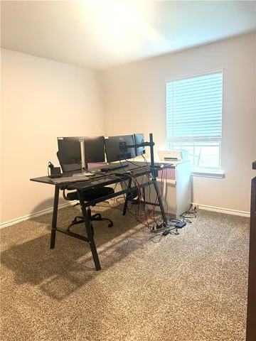 a view of a workspace with furniture and a window