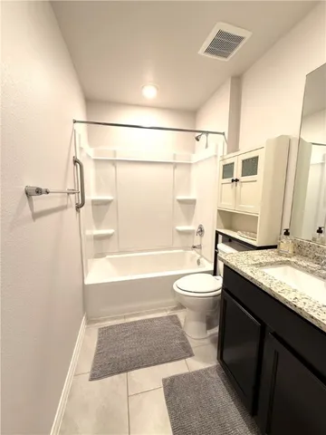 a bathroom with a granite countertop toilet sink and shower