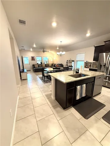 a kitchen with a stove a sink a counter top space and cabinets