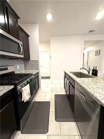 a kitchen with stainless steel appliances granite countertop a sink stove and cabinets