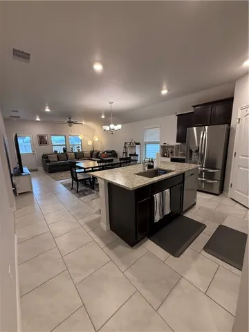 a kitchen with stainless steel appliances granite countertop a stove a sink a refrigerator and cabinets