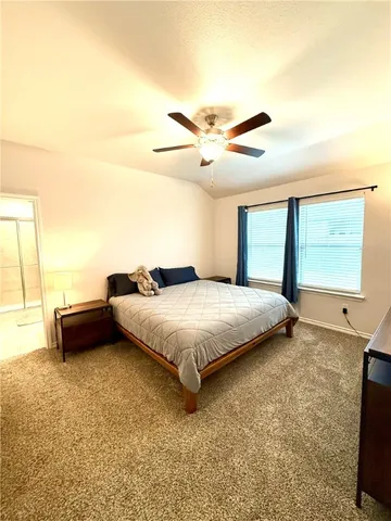 a spacious bedroom with a bed and large windows