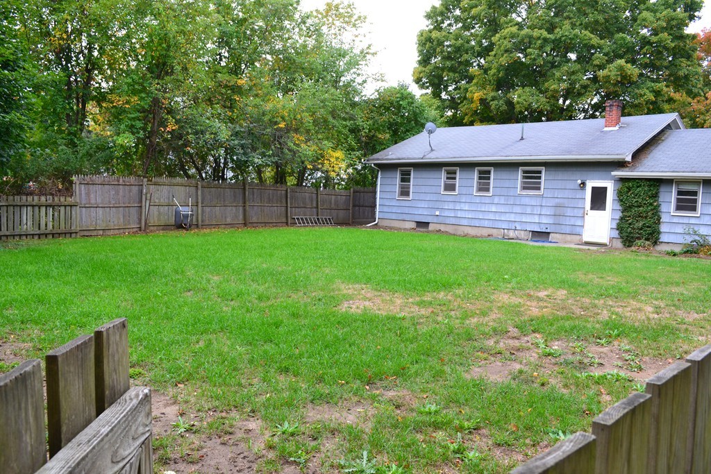 77 North Street Three Rivers, MA 01080 - Photo 18 of 20 a view of a backyard with table and chairs and wooden fence